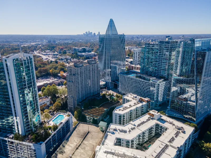 Aerial view of a cityscape with modern high-rise buildings under a clear blue sky.