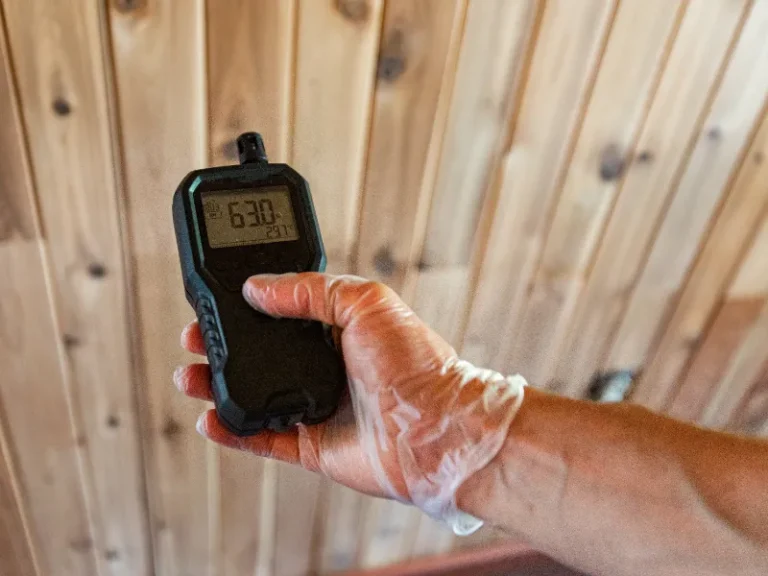 Hand wearing a glove holding a digital device displaying a reading of 630.